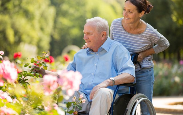 Caregiver walking with a resident through the garden